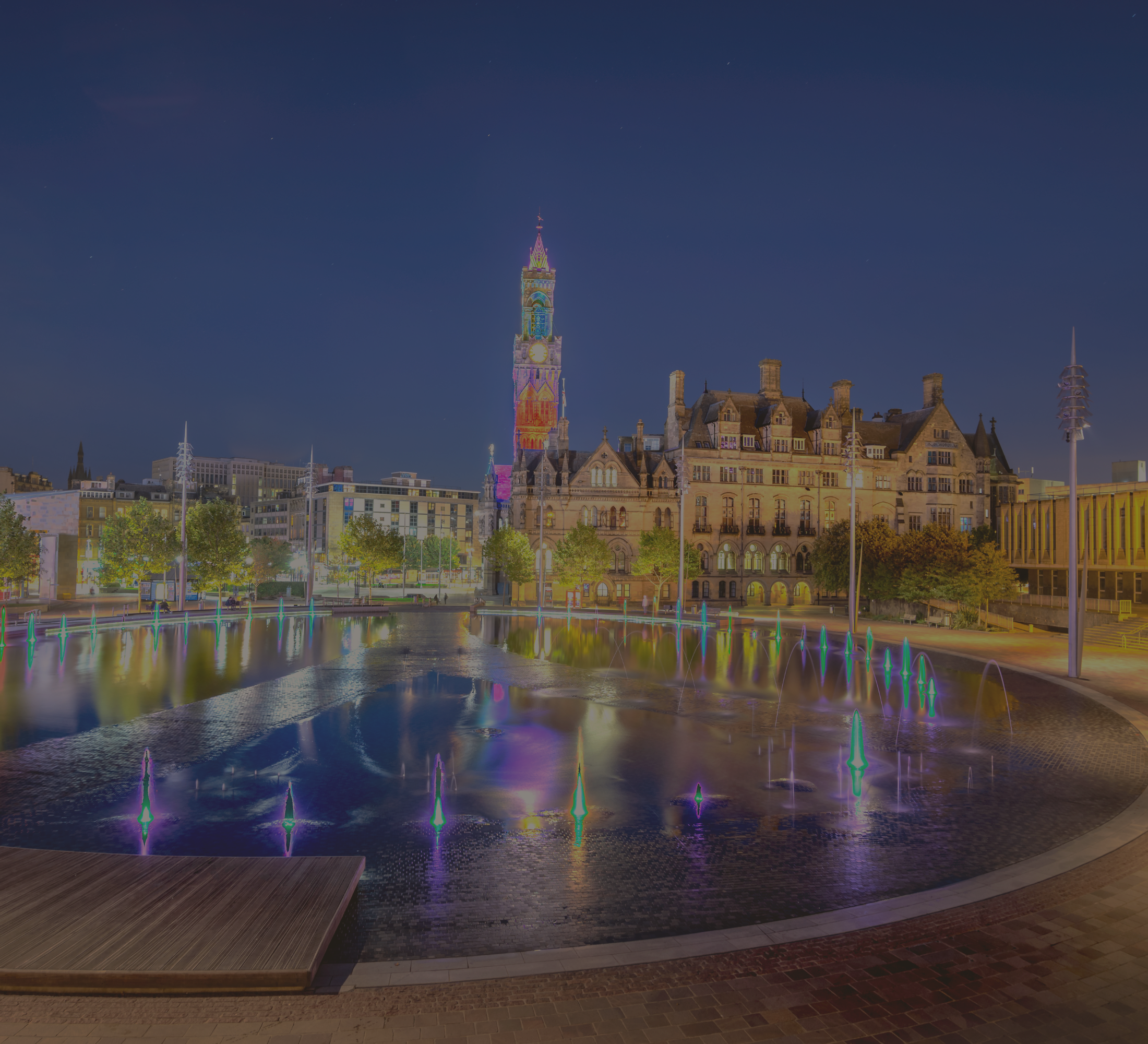 City Hall and Centenary Square illuminated at night in Bradford, UK